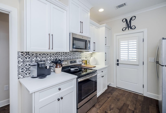 kitchen featuring appliances with stainless steel finishes, backsplash, crown molding, white cabinets, and dark hardwood / wood-style floors