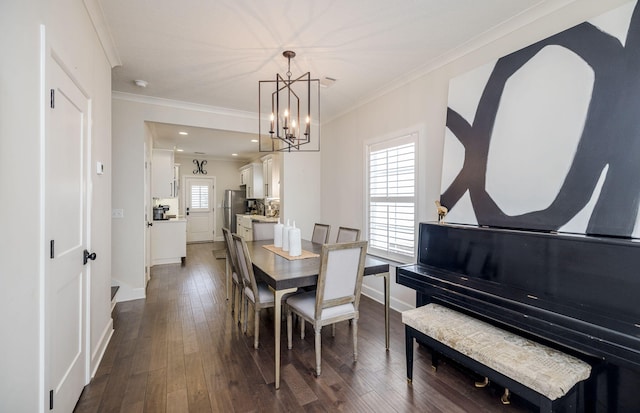 dining area with dark hardwood / wood-style flooring, crown molding, and a chandelier