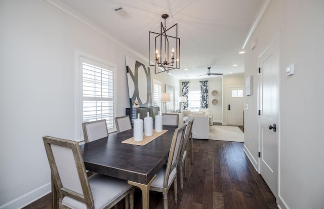 dining room with ceiling fan with notable chandelier, ornamental molding, and dark wood-type flooring