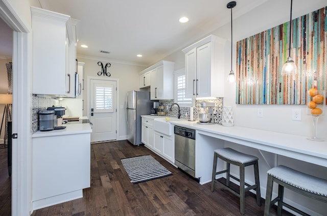 kitchen with white cabinets, appliances with stainless steel finishes, dark wood-type flooring, and pendant lighting