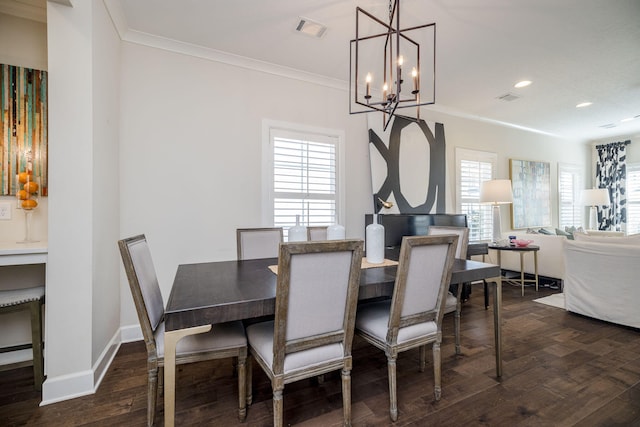 dining space featuring dark hardwood / wood-style floors, a healthy amount of sunlight, crown molding, and a chandelier