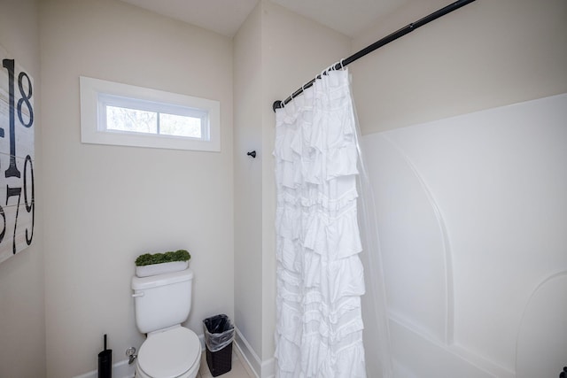 bathroom with a shower with curtain and toilet