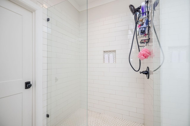 bathroom featuring a shower with door and crown molding