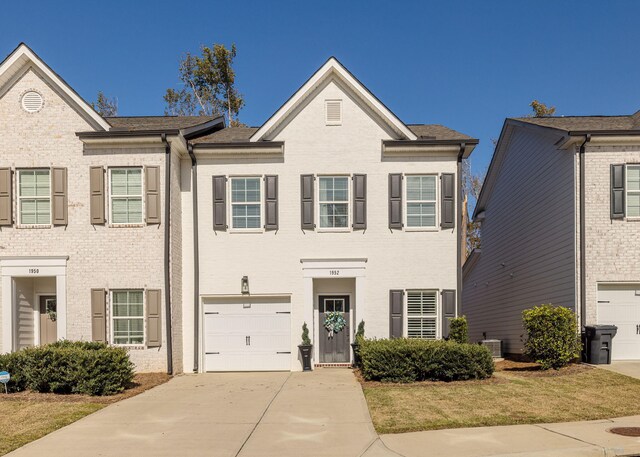 view of front of property with a garage and central air condition unit