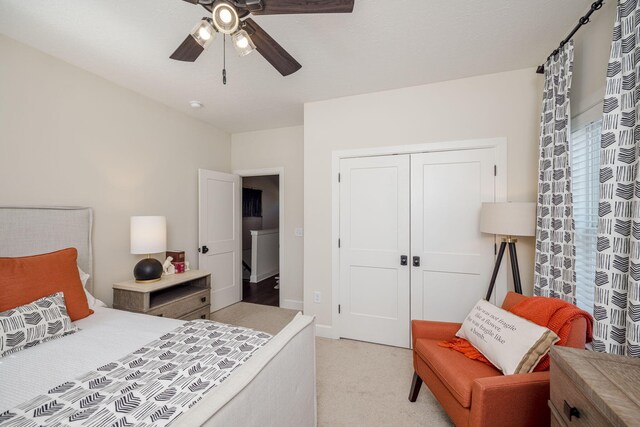 bedroom with ceiling fan, light colored carpet, and a closet