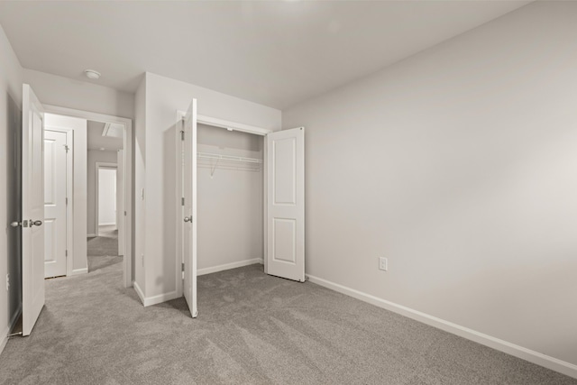 unfurnished bedroom featuring a closet and light carpet