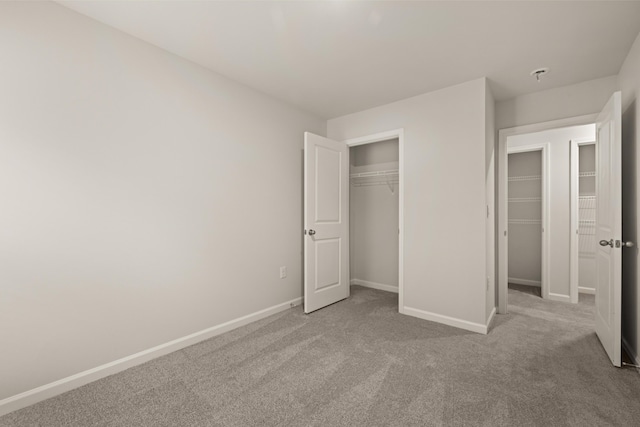 unfurnished bedroom with a closet and light carpet