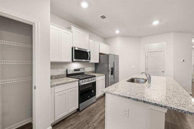 kitchen featuring hardwood / wood-style flooring, stainless steel appliances, an island with sink, white cabinets, and sink