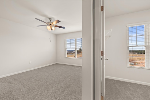 carpeted spare room featuring ceiling fan