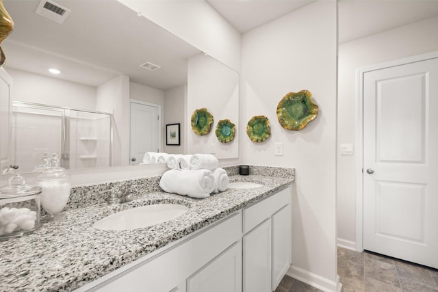 bathroom featuring a shower with door and vanity