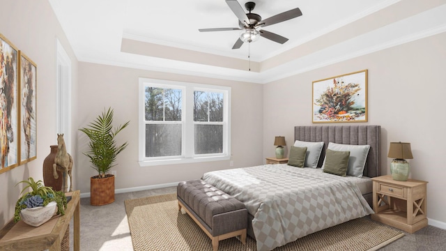 bedroom featuring ornamental molding, light carpet, ceiling fan, and a tray ceiling