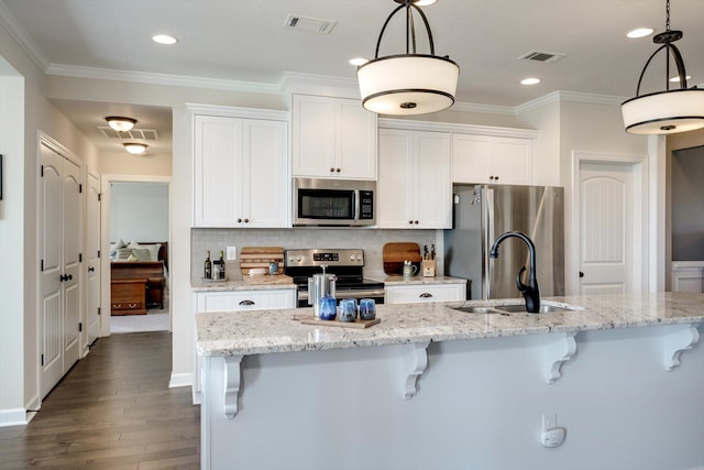 1391 Ackerman Dr, Graniteville, SC 29829 - kitchen featuring appliances with stainless steel finishes, a sink, a breakfast bar, white cabinets, and tasteful backsplash