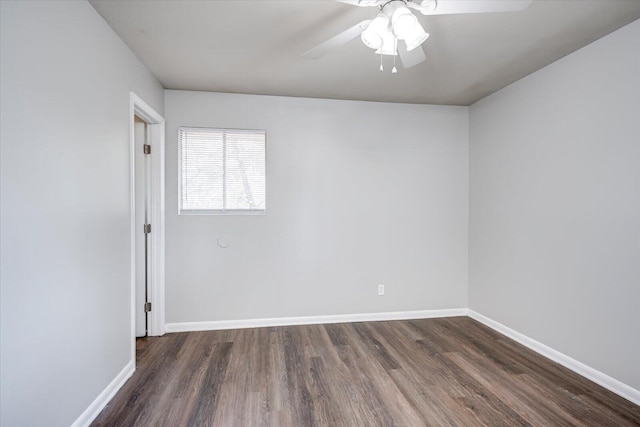 unfurnished room with dark wood-type flooring, a ceiling fan, and baseboards