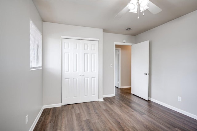 unfurnished bedroom featuring visible vents, baseboards, wood finished floors, a closet, and a ceiling fan