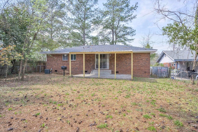 back of house featuring a lawn, a patio, central AC, a fenced backyard, and brick siding