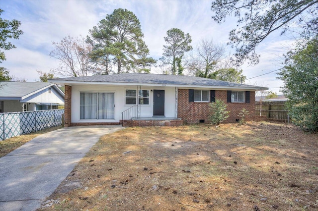 ranch-style house featuring concrete driveway, fence, brick siding, and crawl space