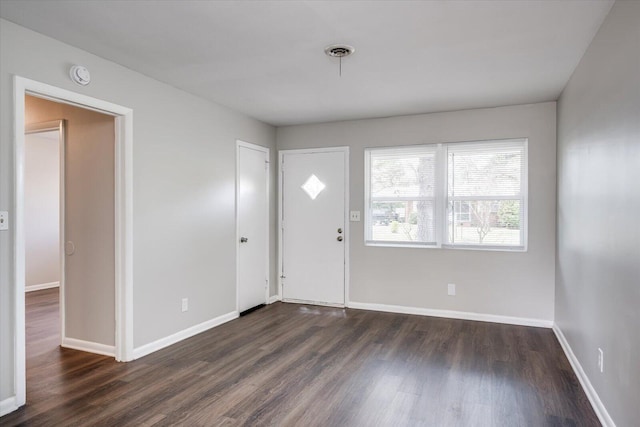 foyer with dark wood-style floors and baseboards