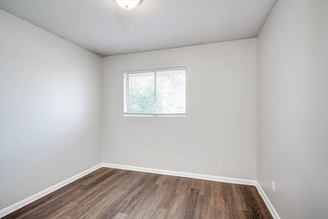 empty room featuring dark wood-style floors and baseboards