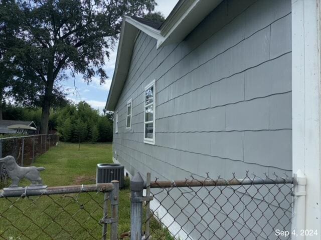 view of property exterior featuring a lawn and central AC