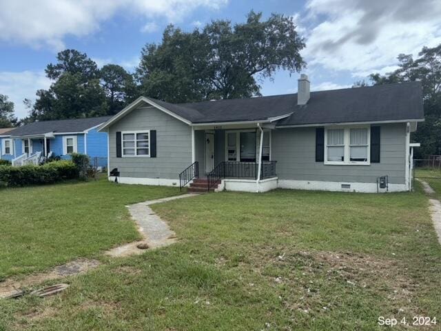 ranch-style house with a porch and a front yard