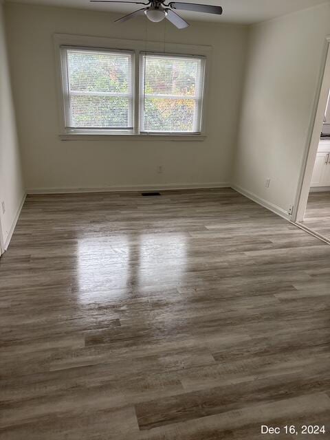 unfurnished room featuring plenty of natural light, ceiling fan, and wood-type flooring