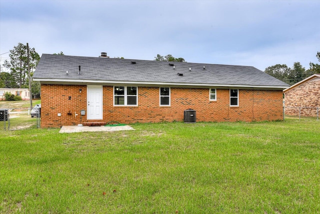 rear view of property featuring a lawn, central AC, and a patio area