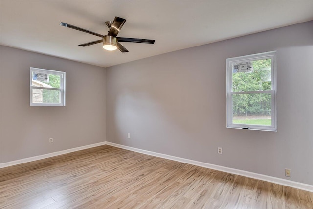 spare room featuring ceiling fan, a healthy amount of sunlight, and light hardwood / wood-style floors