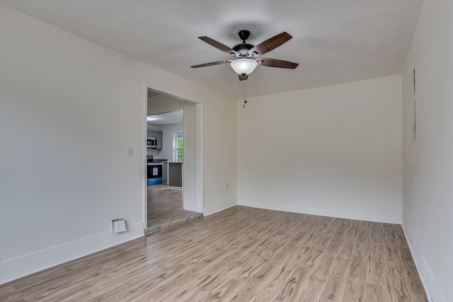 spare room with ceiling fan and light hardwood / wood-style flooring