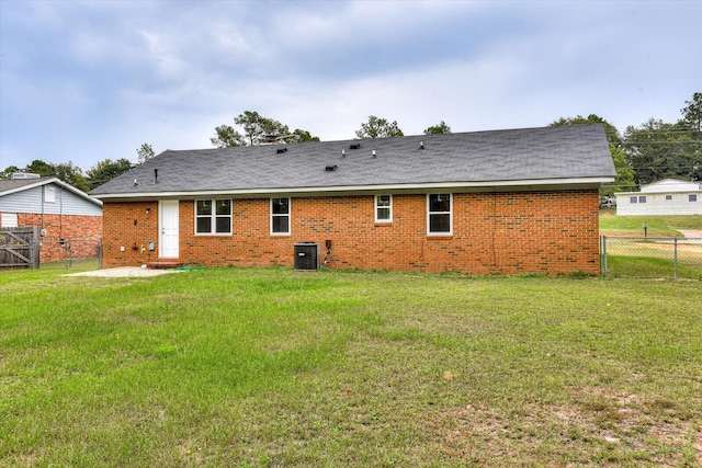 back of property with a lawn and central AC unit