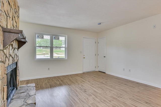 unfurnished living room with a fireplace and light wood-type flooring