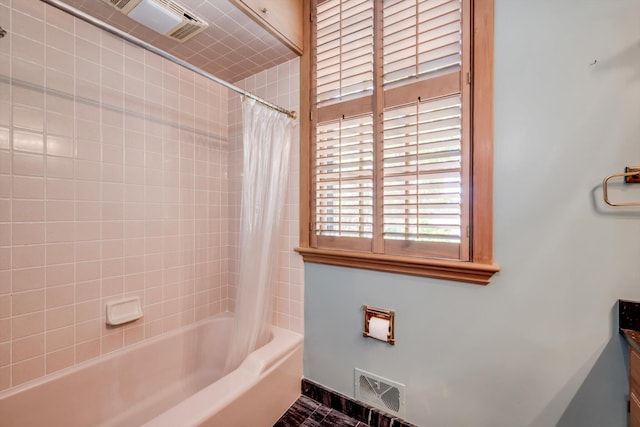 full bath featuring shower / bath combo, baseboards, and vanity