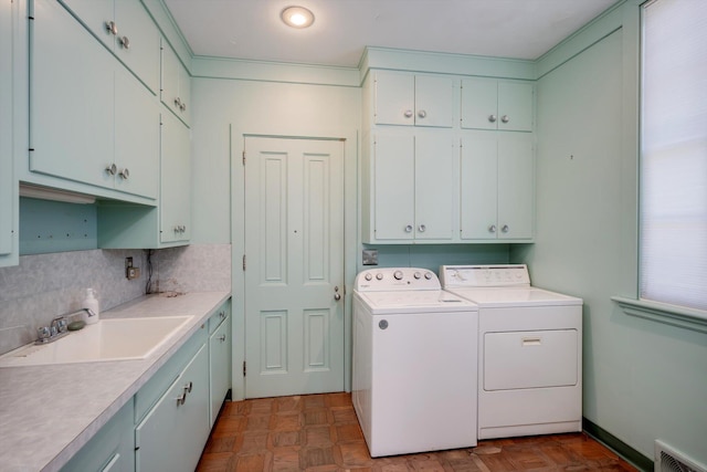 clothes washing area featuring cabinet space and separate washer and dryer