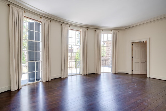 unfurnished room with dark wood-type flooring, crown molding, and baseboards