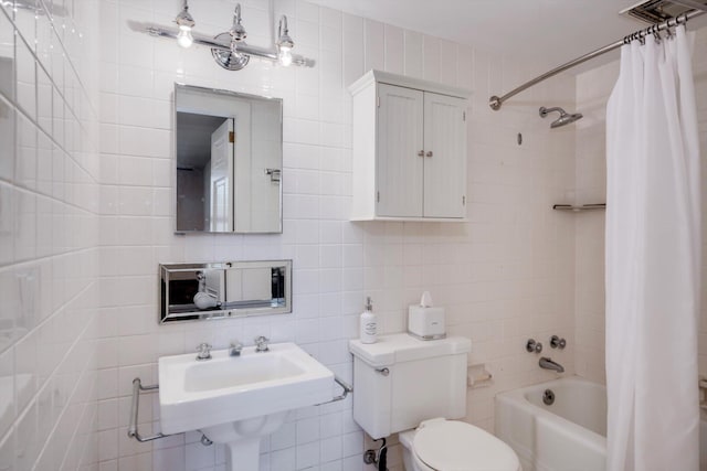 full bath with tile walls, toilet, tasteful backsplash, shower / tub combo, and a sink
