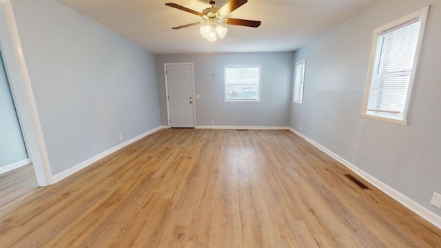 spare room with ceiling fan and light wood-type flooring