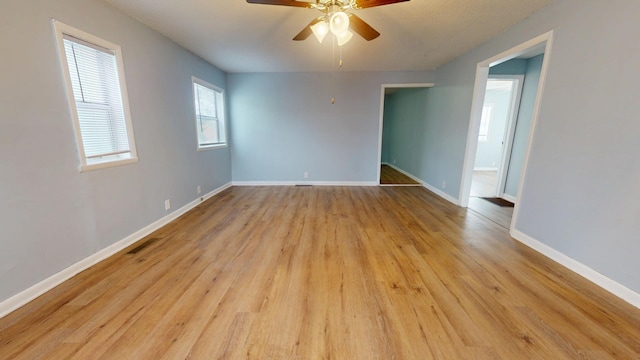 spare room with ceiling fan and light wood-type flooring