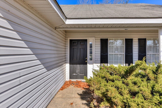 property entrance featuring roof with shingles