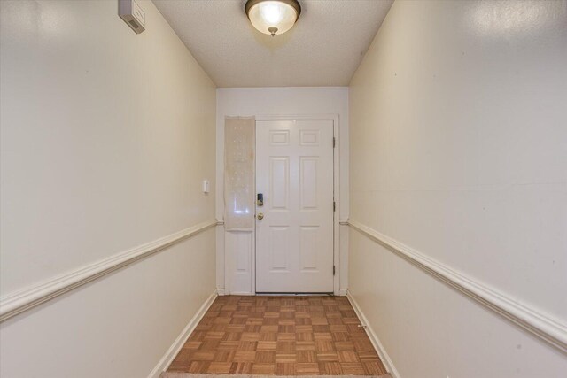 entryway with a textured ceiling and baseboards