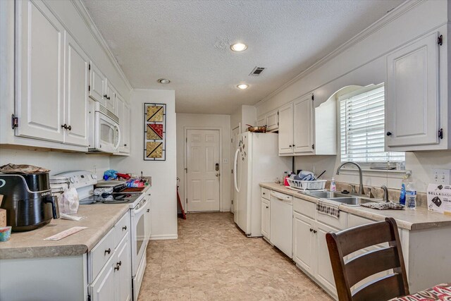 kitchen featuring light countertops, white appliances, a sink, and white cabinets