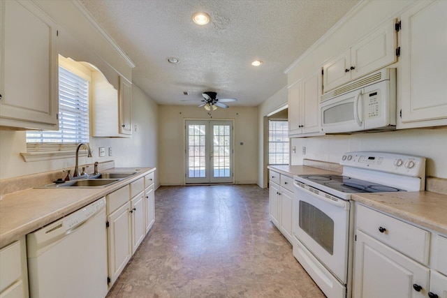 kitchen featuring french doors, light countertops, a sink, a textured ceiling, and white appliances