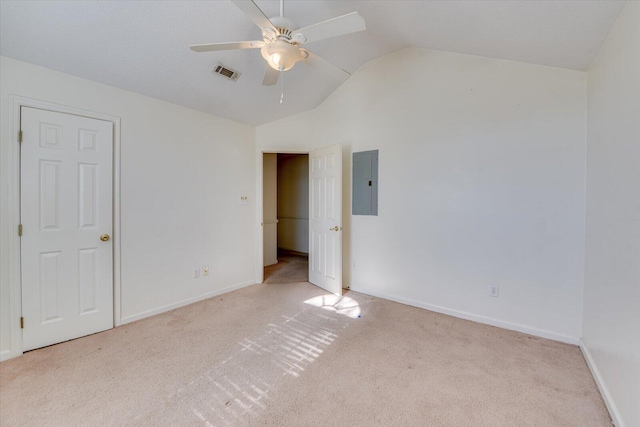 unfurnished bedroom featuring carpet, electric panel, visible vents, and vaulted ceiling