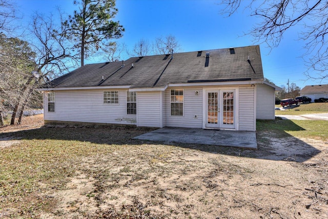 back of house with a patio area, roof with shingles, a lawn, and french doors