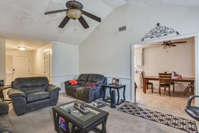 carpeted living room with high vaulted ceiling, a textured ceiling, visible vents, and a ceiling fan