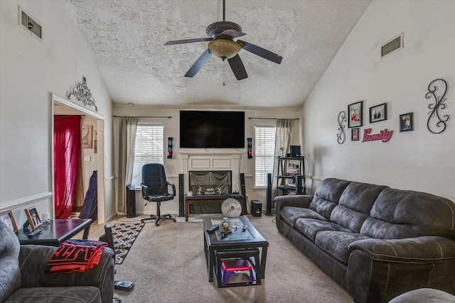 carpeted living room with vaulted ceiling, a wealth of natural light, and visible vents