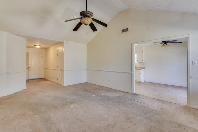 empty room featuring light carpet, high vaulted ceiling, ceiling fan, and visible vents