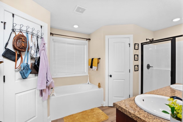 bathroom with vanity, wood-type flooring, and shower with separate bathtub