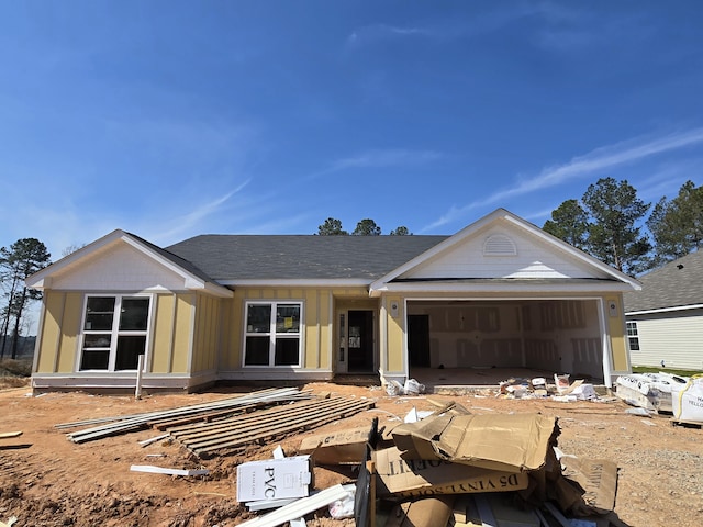 view of front of property featuring an attached garage, board and batten siding, and roof with shingles