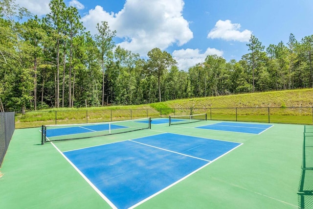 view of tennis court with community basketball court and fence