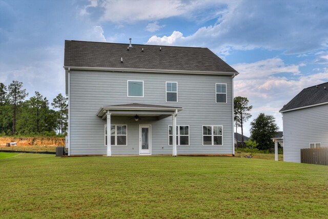 back of house featuring ceiling fan and a lawn