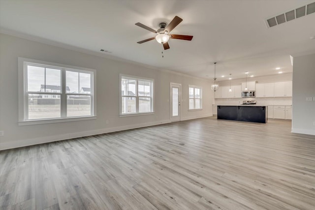 unfurnished living room featuring ceiling fan, light wood-type flooring, and crown molding